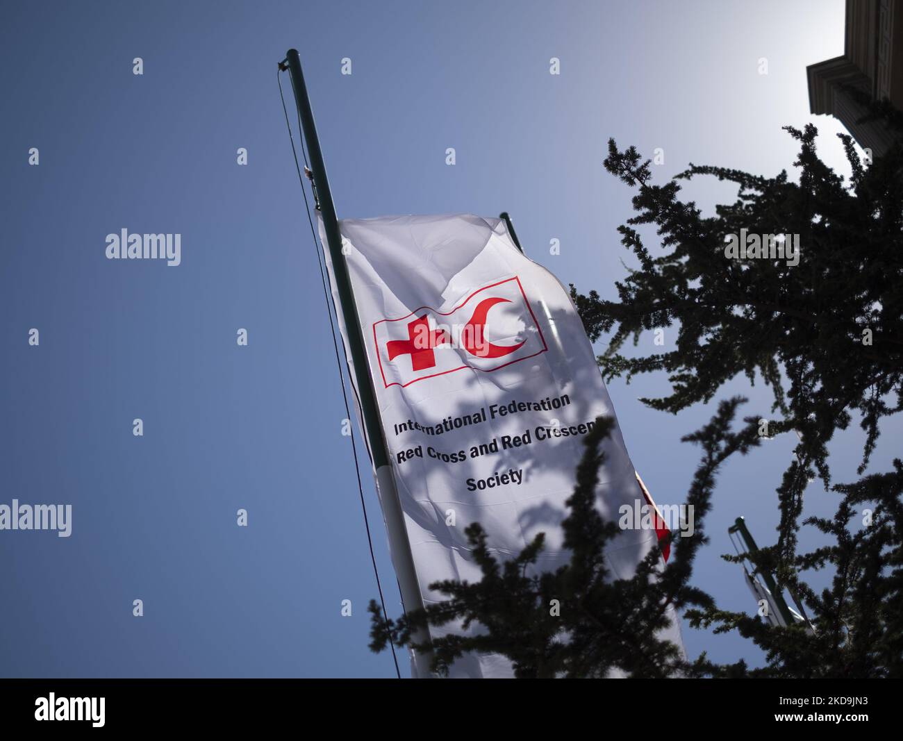 Eine Fahne mit Zeichen der Internationalen Rotkreuzgesellschaft (L) und der Iranischen Rothalbmondgesellschaft schwenkt im Süden Teherans während einer Zeremonie anlässlich des 100.. Jahrestages der Gründung der Organisation am 9. Mai 2022. (Foto von Morteza Nikoubazl/NurPhoto) Stockfoto