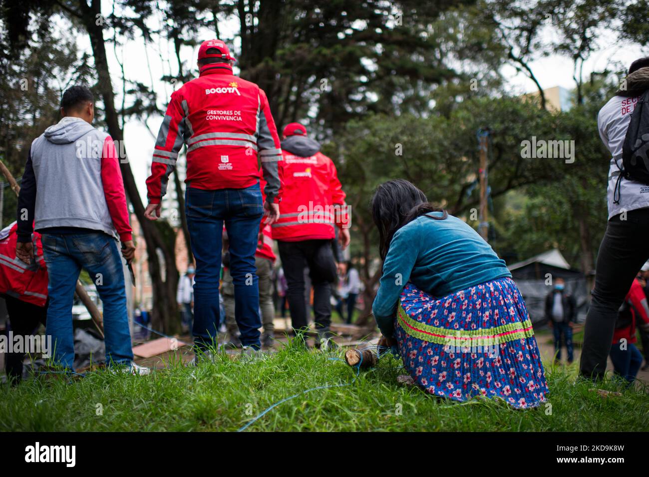 Eine indigene Mutter von Embera hilft Mitgliedern des Sozialamts von Bogota, einen Schuppen abzubauen, da die indigenen Gemeinschaften von Embera das provisorische Lager verlassen, das vor 8 Monaten errichtet wurde, wo mehr als 1000 durch Konflikte vertriebene indigene Menschen lebten und Vereinbarungen mit der Regierung getroffen haben, die an einen nahegelegenen Ort verlegt werden sollen Vor der Rückkehr in ihre Gebiete, in Bogota, Kolumbien, 9. Mai 2022. (Foto von Sebastian Barros/NurPhoto) Stockfoto