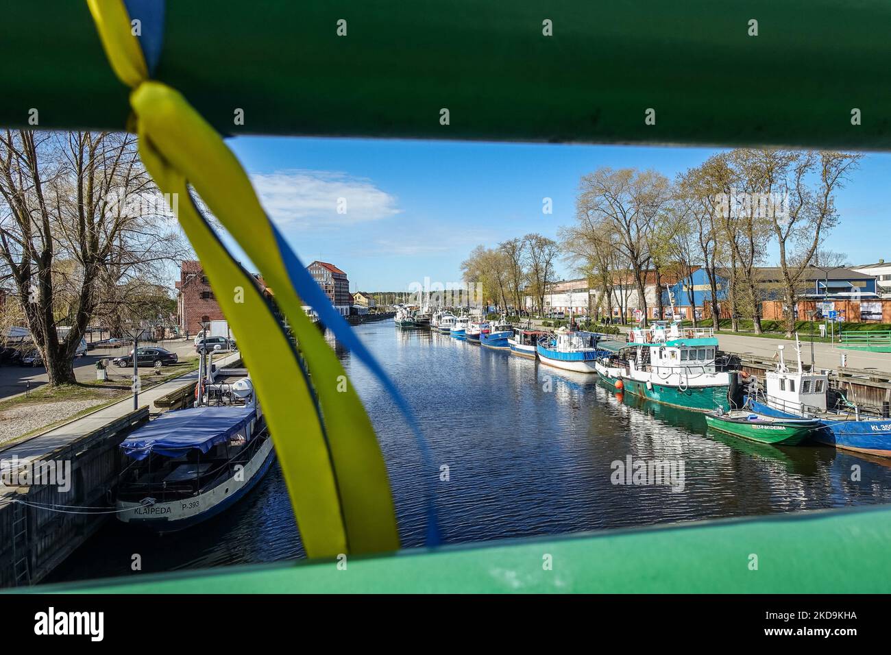 Allgemeine Ansicht der Fischerboote auf dem Fluss Akmena - Dane (Dange, Danija) mit einem Band in den Farben der ukrainischen Flagge, die an der Brücke befestigt ist, ist am 30. April 2022 in Klaipeda, Litauen zu sehen (Foto: Michal Fludra/NurPhoto) Stockfoto