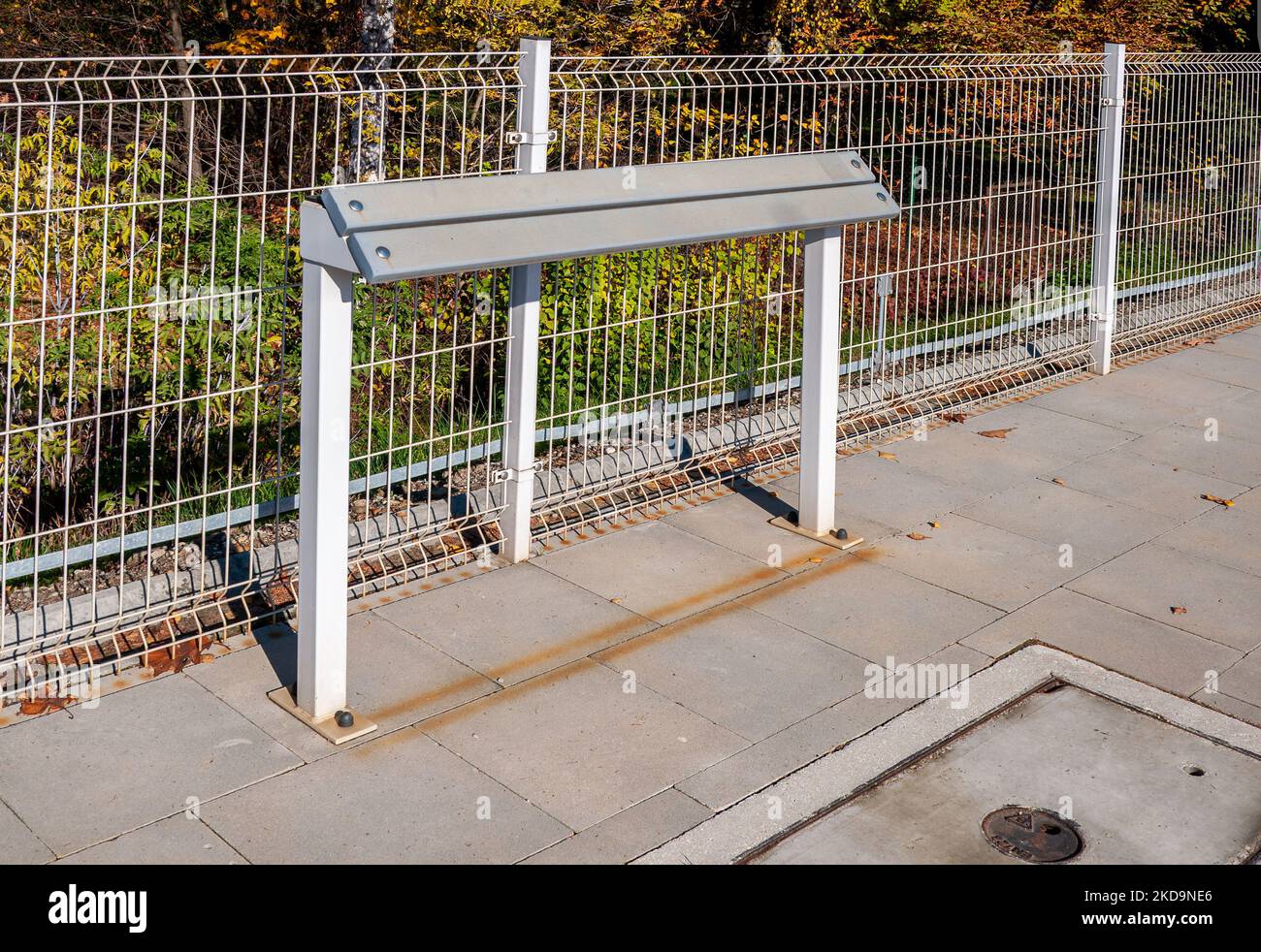 Schiefe Bank oder schiefe Ständer oder schlanke Bar (noch kein etablierter Name) - neue moderne Ersatz der traditionellen Bank auf Bahnhöfen, Bus oder Straßenbahn Stockfoto