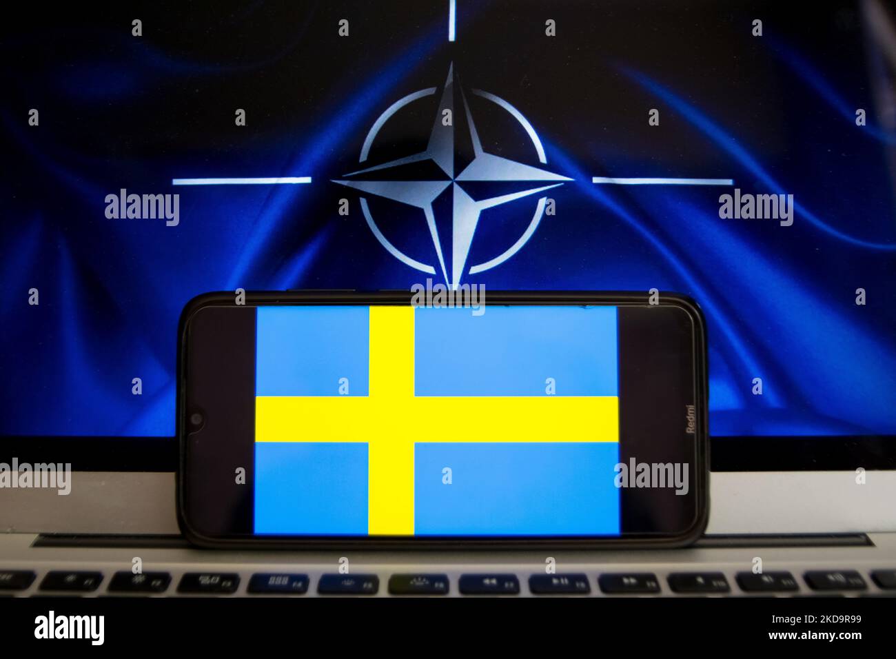 In dieser Abbildung ist eine Flagge Schwedens zu sehen, die auf einem Smartphone-Bildschirm mit der Flagge der NATO im Hintergrund in Athen, Griechenland, am 12. Mai 2022 angezeigt wird. Finnland und Schweden beantragten den Beitritt zur NATO. (Foto-Illustration von Nikolas Kokovlis/NurPhoto) Stockfoto