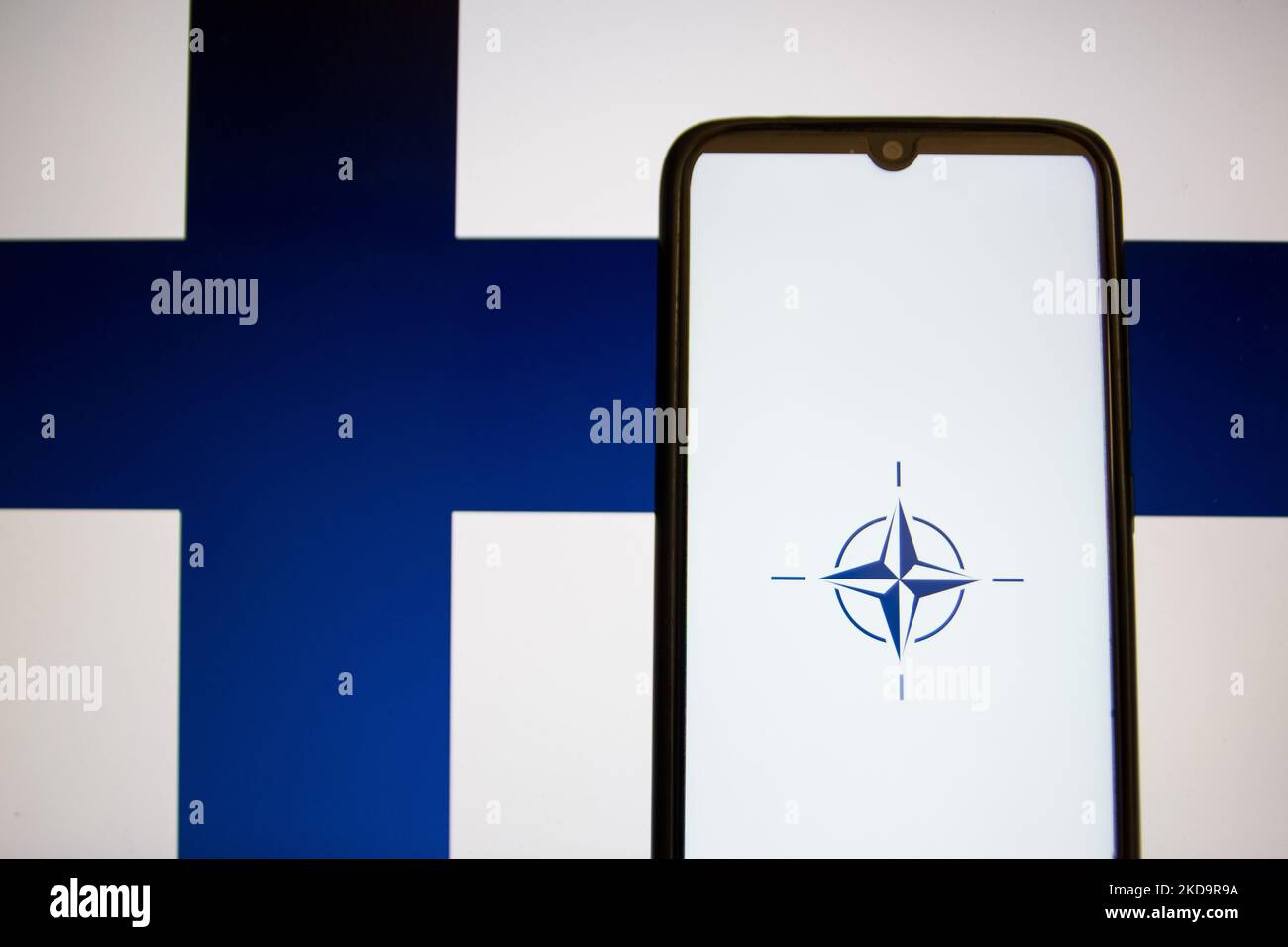 Auf dieser Abbildung ist eine Flagge der NATO zu sehen, die auf einem Smartphone-Bildschirm mit der Flagge Finnlands im Hintergrund in Athen, Griechenland, am 12. Mai 2022 angezeigt wird. Finnland und Schweden beantragten den Beitritt zur NATO. (Foto-Illustration von Nikolas Kokovlis/NurPhoto) Stockfoto