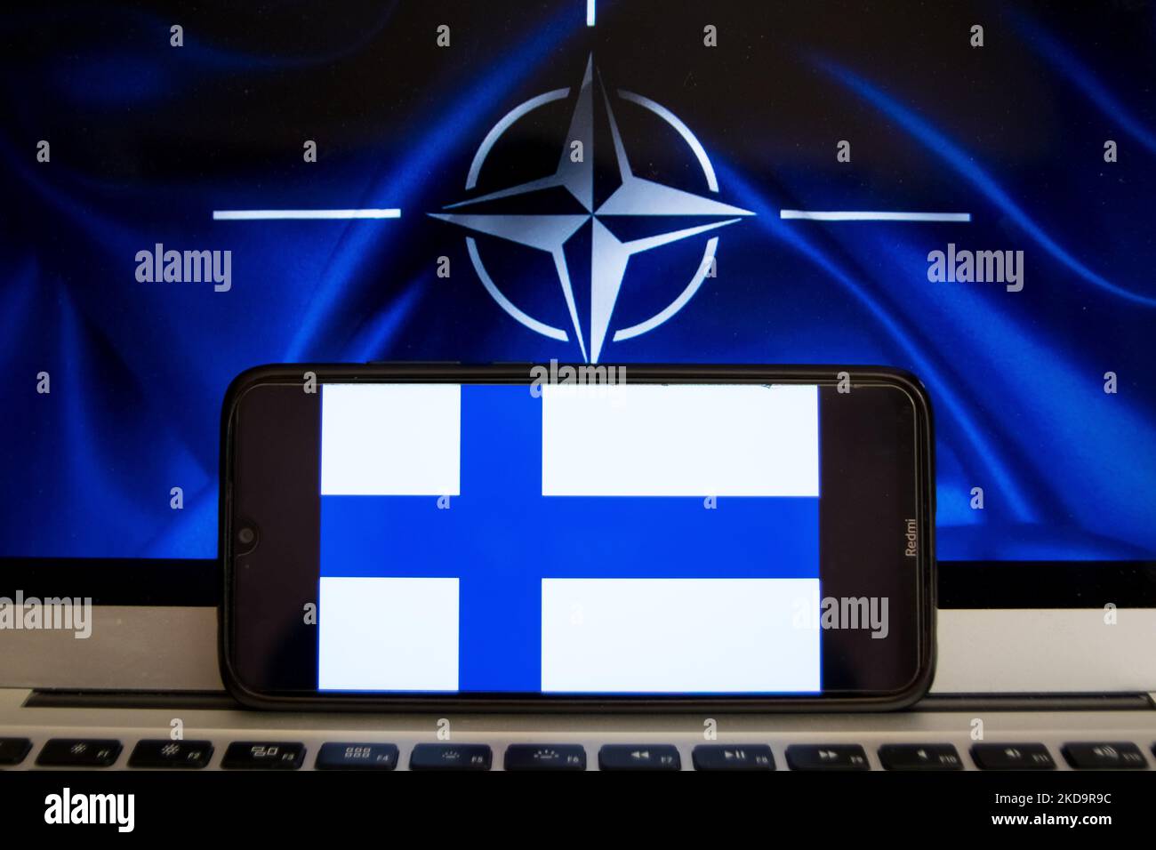 Auf dieser Abbildung ist eine Flagge Finnlands zu sehen, die auf einem Smartphone-Bildschirm mit der Flagge der NATO im Hintergrund in Athen, Griechenland, am 12. Mai 2022 angezeigt wird. Finnland und Schweden beantragten den Beitritt zur NATO. (Foto-Illustration von Nikolas Kokovlis/NurPhoto) Stockfoto