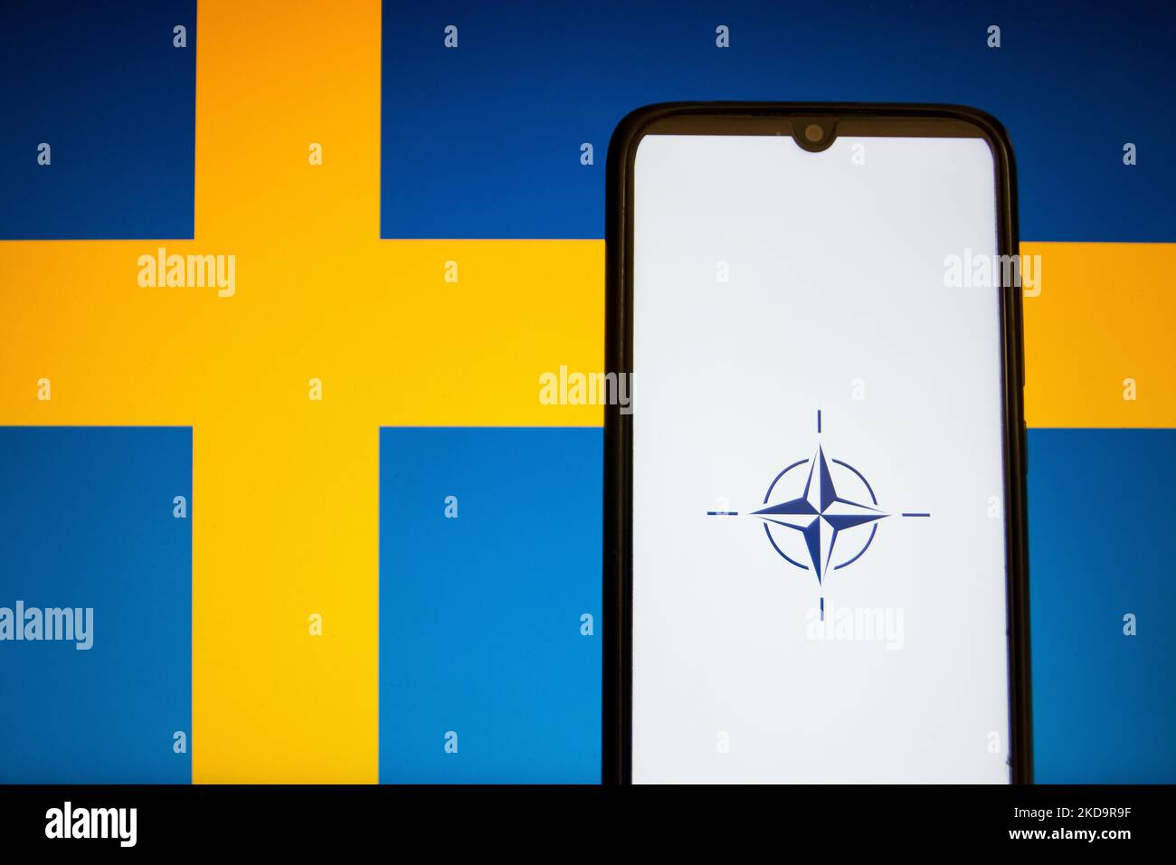 Auf dieser Abbildung ist eine Flagge der NATO zu sehen, die auf einem Smartphone-Bildschirm mit der Flagge Schwedens im Hintergrund in Athen, Griechenland, am 12. Mai 2022 angezeigt wird. Finnland und Schweden beantragten den Beitritt zur NATO. (Foto-Illustration von Nikolas Kokovlis/NurPhoto) Stockfoto