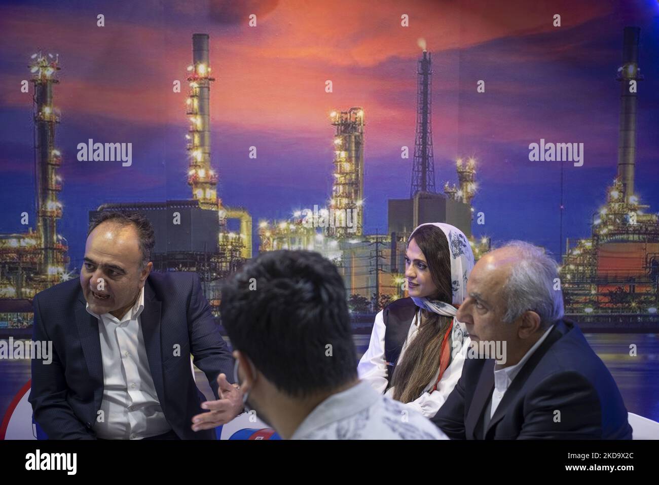 Zwei Jahre nach dem Ausbruch der COVID-19 im Iran spricht ein nicht identifizierter iranischer Ölexperte (L) mit Aktivisten der Öl- und Gasindustrie, während er am 13. Mai 2022 vor einem Bild von Öleinrichtungen auf der Internationalen Ausstellung für Öl, Gas, Raffinierung und Petrochemie 26. in Teheran sitzt. (Foto von Morteza Nikoubazl/NurPhoto) Stockfoto