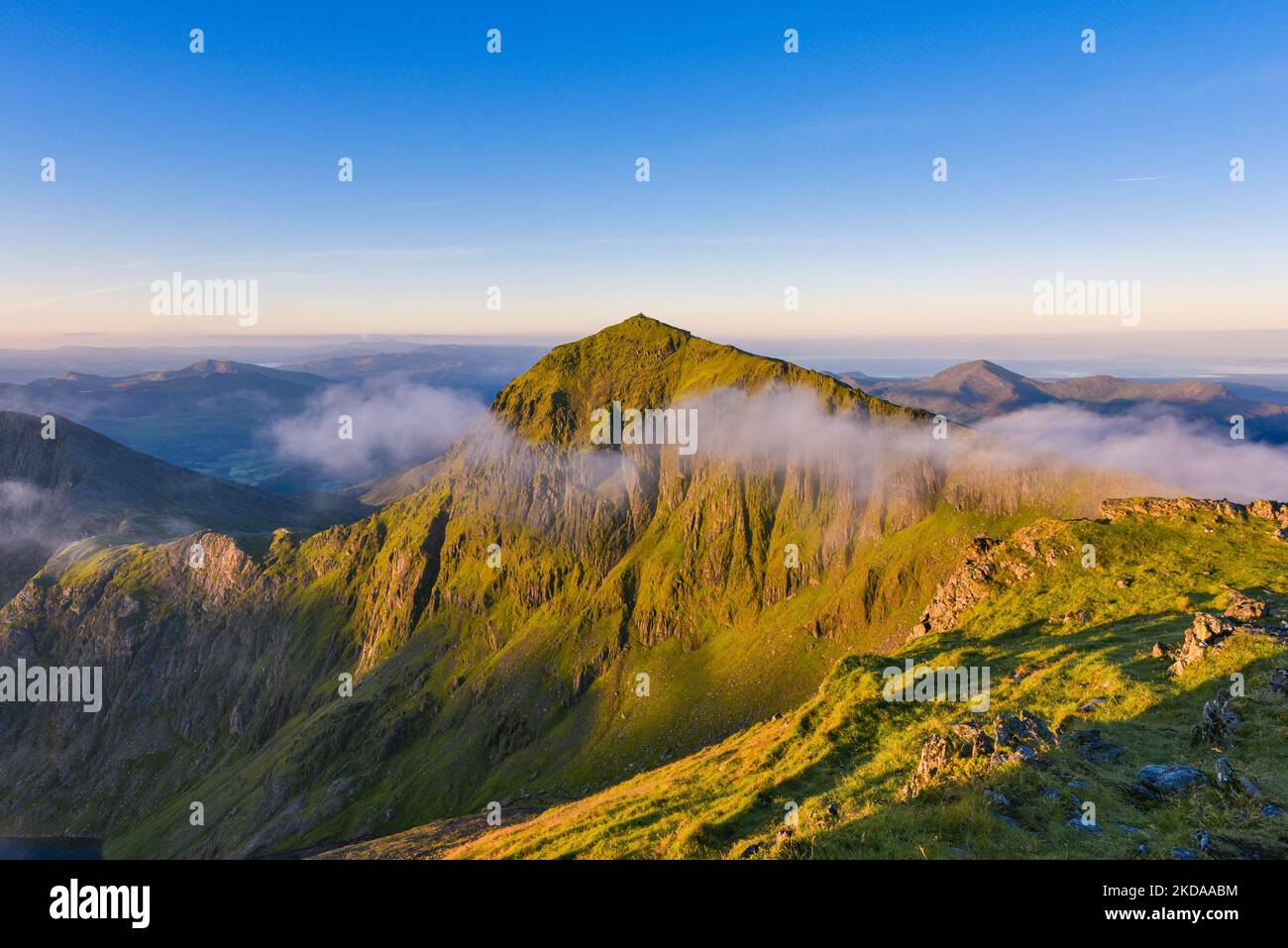 Blick auf den nebligen Sonnenaufgang auf dem Snowdon-Gipfel, Snowdonia National Park. Schöner Sommermorgen in Nordwales, Snowdon Gipfel umgeben von Nebel. Stockfoto