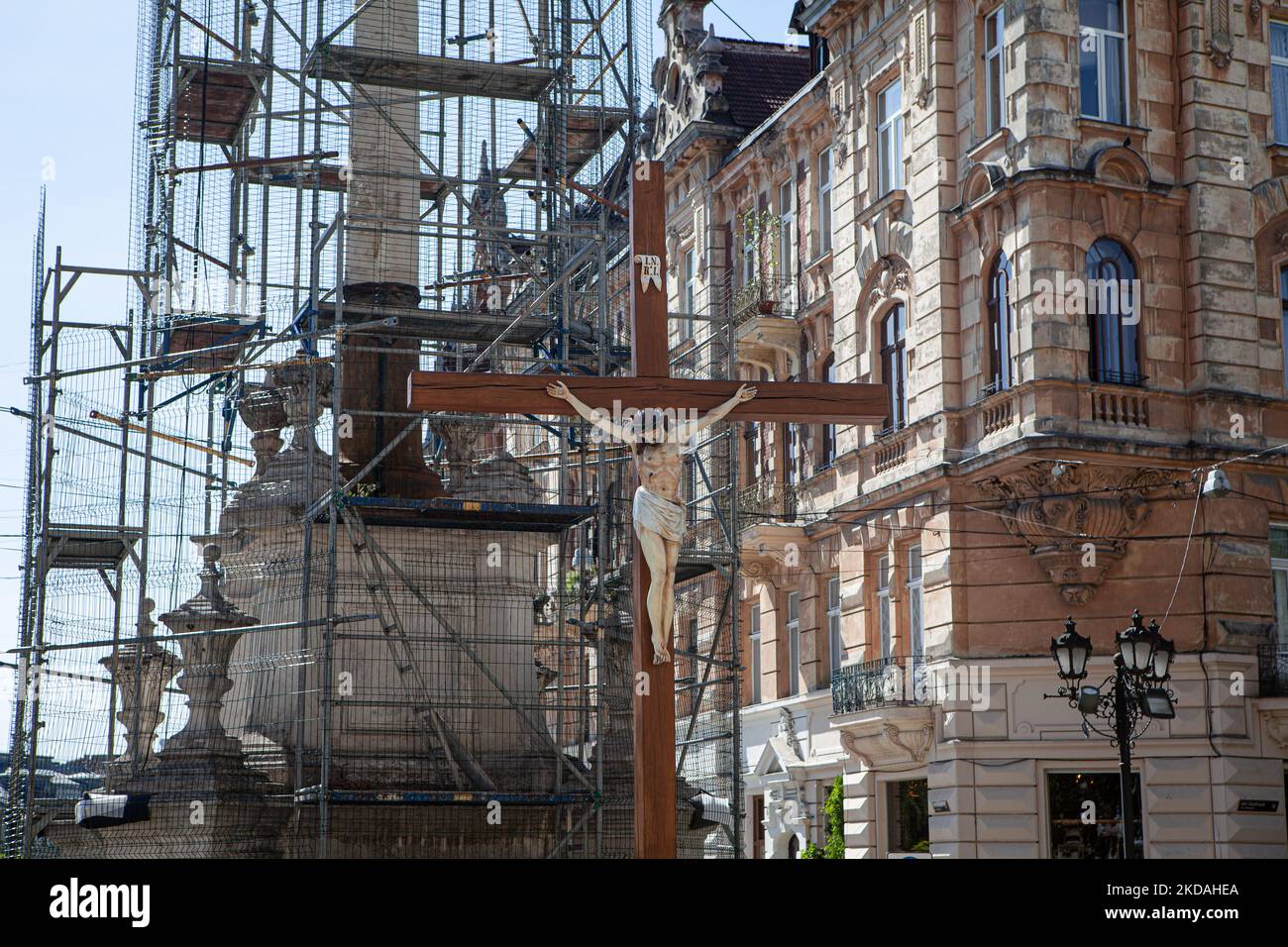 Neben einem Kruzifix ist eine Statue bedeckt, um sie vor möglichen Raketenangriffen in Lemberg am 19. Mai 2022 zu schützen. Obwohl Lemberg seit der russischen Invasion am 24. Februar nicht mehr das gleiche Ausmaß an Angriffen wie andere Regionen der Ukraine erlitten hat, gibt es immer noch regelmäßige Angriffe auf die Stadt. (Foto von Richard Wright/NurPhoto) Stockfoto