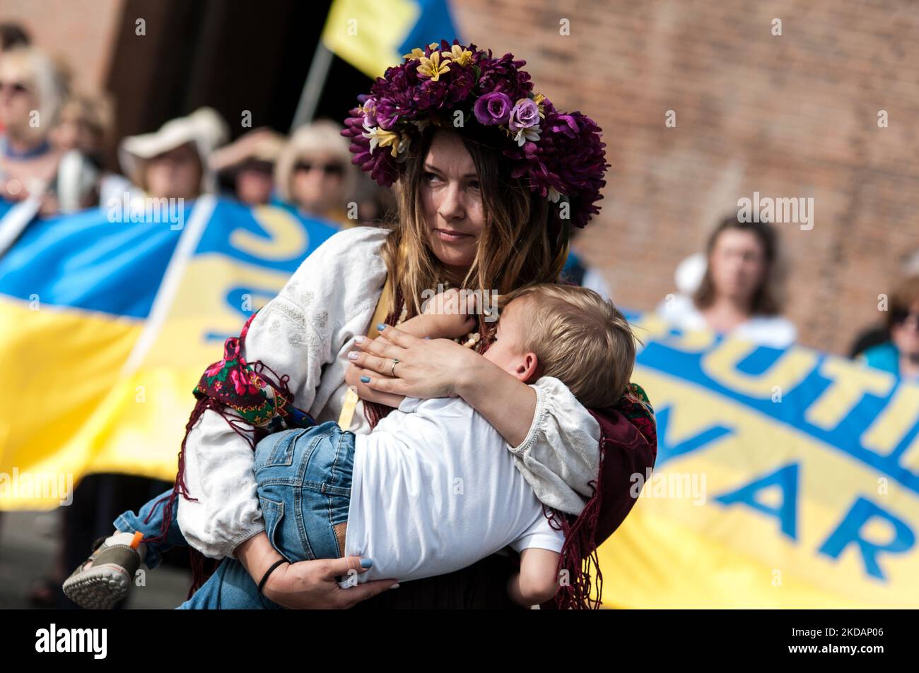 Eine Ansicht einer Frau in Veschywanka (dem traditionellen ukrainischen bestickten Hemd), die ein Kind festhält, und Putin, der mit blutigen Händen vorrückt, während einer Flashmob der ukrainischen Gemeinschaft in Rom, Italien, während einer Demonstration, die aufgerufen wurde, „keinen Krieg mehr“ zu sagen, am 22. Mai 2022 in Rom, Italien, eine Sense zu fassen. (Foto von Andrea Ronchini/NurPhoto) Stockfoto