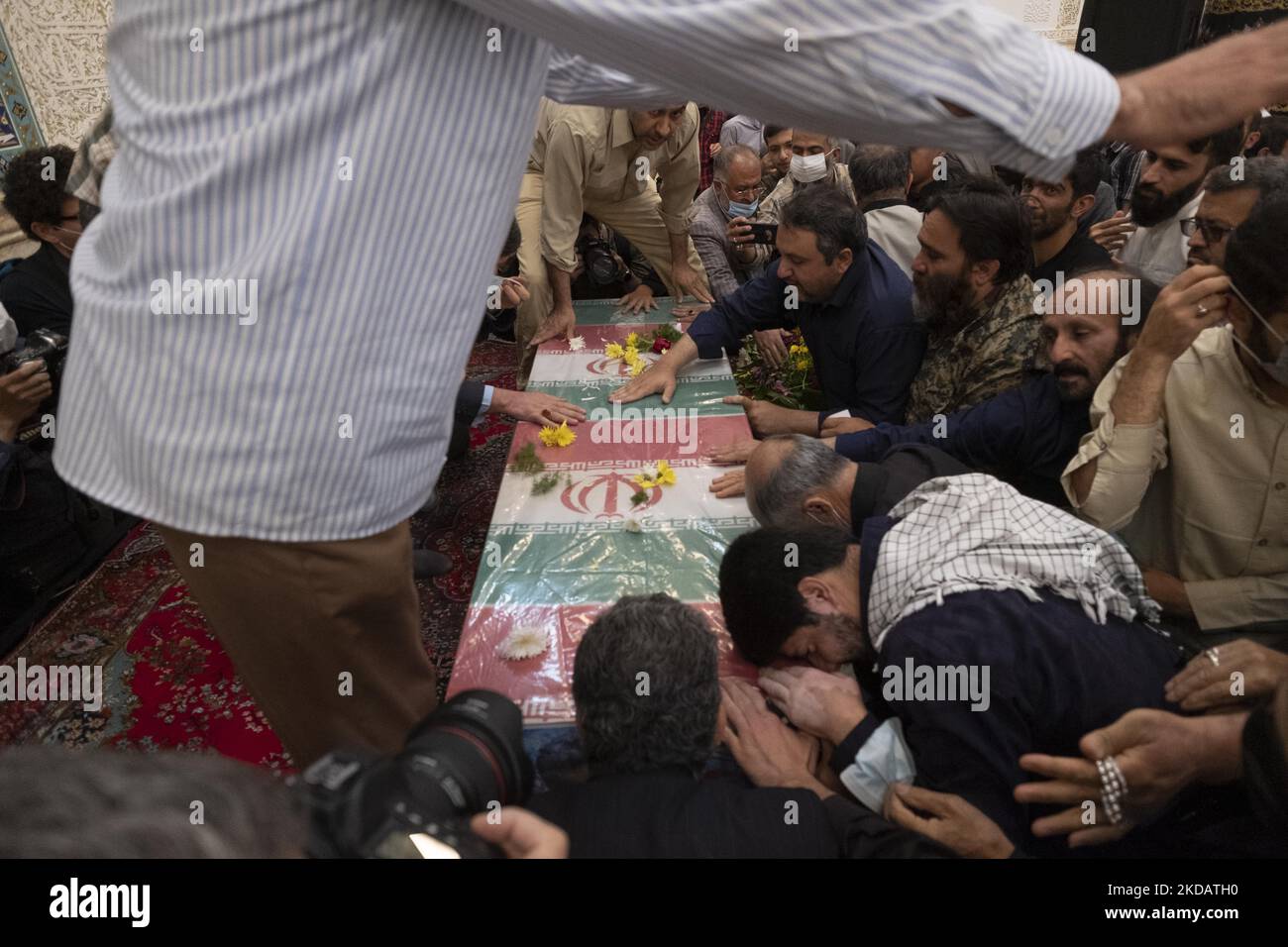 Iranische Männer trauern am 24. Mai 2022 während der Beerdigung von Khodai in einer Moschee im Süden Teherans neben dem Sarg, in dem sich der Leichnam des Obersten des Islamischen Revolutionsgarden (IRGC), Sayyad Khodai, befindet. Oberst Sayyad Khodai vom Korps der Islamischen Revolutionsgarde (IRGC) wurde am 22. Mai vor seinem Haus von Motorradmördern in Teheran getötet. (Foto von Morteza Nikoubazl/NurPhoto) Stockfoto