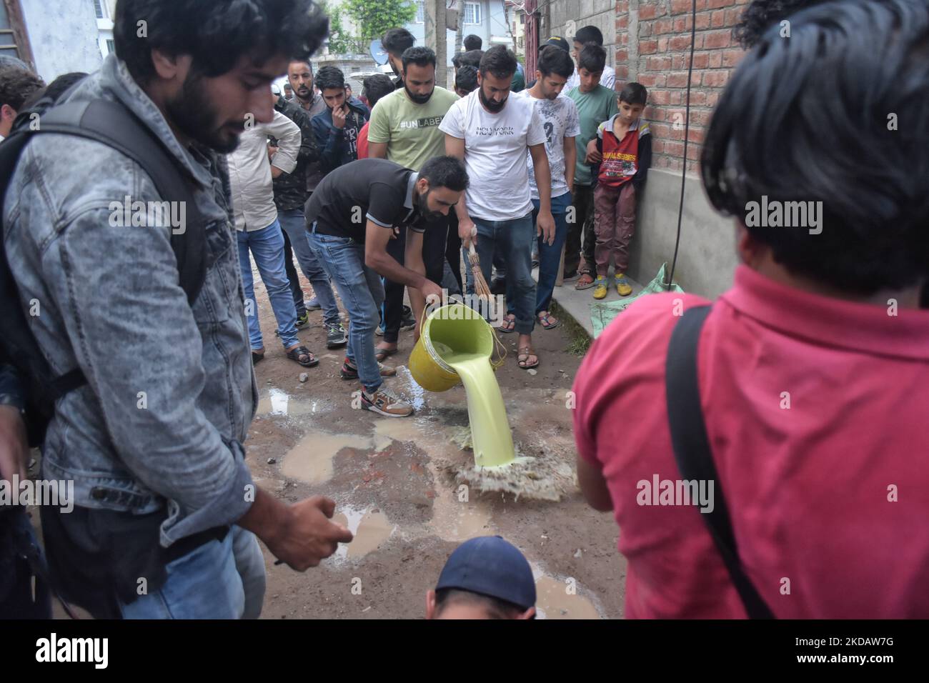 Menschen waschen die Blutflecken in der Nähe der Stelle, an der ein Polizist Saifullah Qadri am 24. Mai 2022 im Anchar-Viertel im Gebiet von Soura, dem indischen Srinagar, Kaschmir verabreicht wurde. Qadri wurde von seiner Tochter begleitet, als er angegriffen wurde. Beide wurden zum Sher-i-Kashmir Institute of Medical Sciences (SKIMS), Srinagar, gebracht, wo Qadri erlag. (Foto von Muzamil Mattoo/NurPhoto) Stockfoto