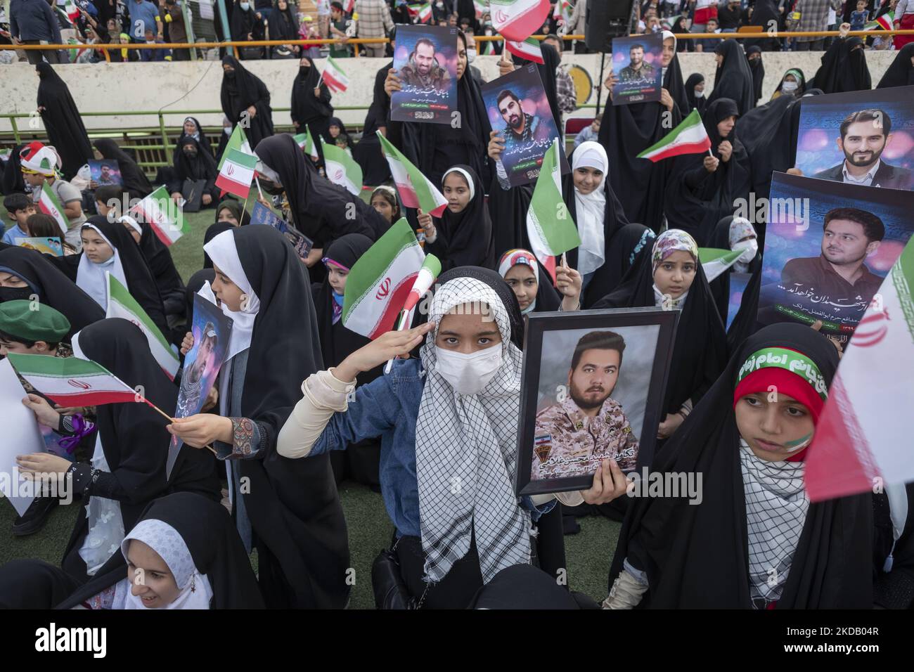 Die Tochter eines Märtyrers des Schreinverteidigers hält ein Porträt ihres Vaters, der während seines Kampfes gegen ISIS-Milizen getötet wurde, grüßt während einer Versammlung, um den Hymnus Hallo Commander zur Unterstützung des iranischen Obersten Führers Ayatollah Ali Khamenei zu singen, Am 26. Mai 2022 im Azadi (Freedom) Fußballstadion im Westen von Teheran mit hunderttausend Sitzplätzen. Hunderttausend Anhänger des iranischen Obersten Führers Ayatollah Ali Khamenei versammelten sich im Sportkomplex Azadi (Freiheit), um den Hymnus Hallo Kommandant zu singen. (Foto von Morteza Nikoubazl/NurPhoto) Stockfoto