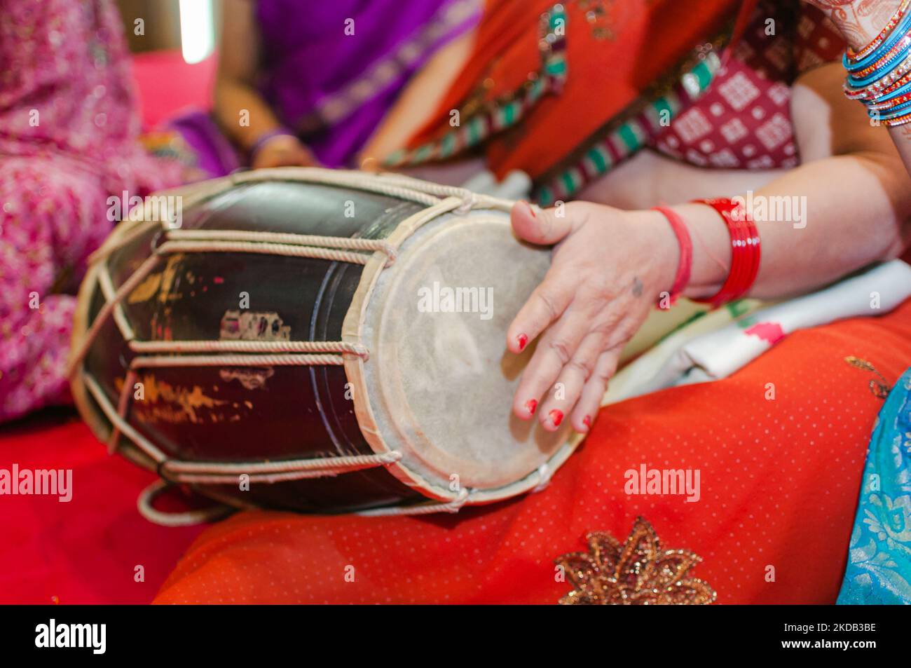 Hand einer indischen Frau, die während des Festivals Dhol, Dholak, Dholki, Trommel spielt, Event, Damen gesanget, mehendi Party. Indische Kultur, Traditiona Stockfoto