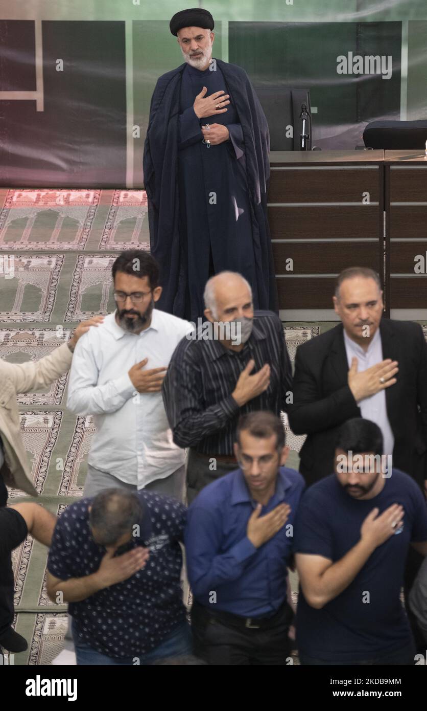 Iranische Männer und ein Geistlicher schlugen sich in einer Moschee im Norden Teherans, während sie an einer Trauerfeier teilnahmen, um an die Opfer des zusammengebrochenen Metropol-Gebäudes zu erinnern, am 31. Mai 2022. Der zehnstöckige Metropole-Komplex stürzte am 23. Mai in der südlichen Stadt Abadan ein und tötete Dutzende. (Foto von Morteza Nikoubazl/NurPhoto) Stockfoto