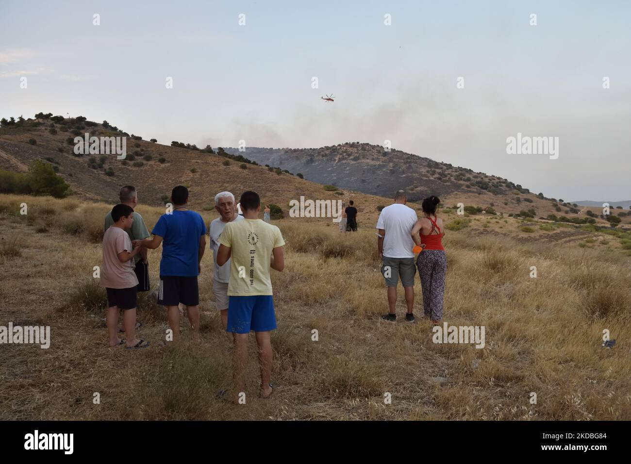 Athen, Griechenland. 4.. Juni 2022. Bewohner beobachten, wie Feuerwehrhubschrauber in der Region Voula operieren. Ein Waldbrand bricht über die Hänge des Berges Hymettus und zwingt die Behörden, Bewohner in einigen Gebieten der südlichen Vororte in Athen, Griechenland, zu evakuieren. (Foto von Nicolas Koutsokostas/NurPhoto) Stockfoto
