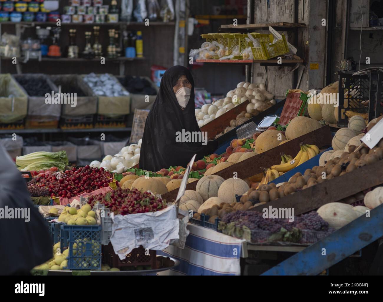 Eine verschleierte Iranerin schaut zu, während sie am 7. Juni 2022 in einem Obst- und Gemüseladen auf dem Shapour Bazaar (Markt) im Süden Teherans steht. (Foto von Morteza Nikoubazl/NurPhoto) Stockfoto