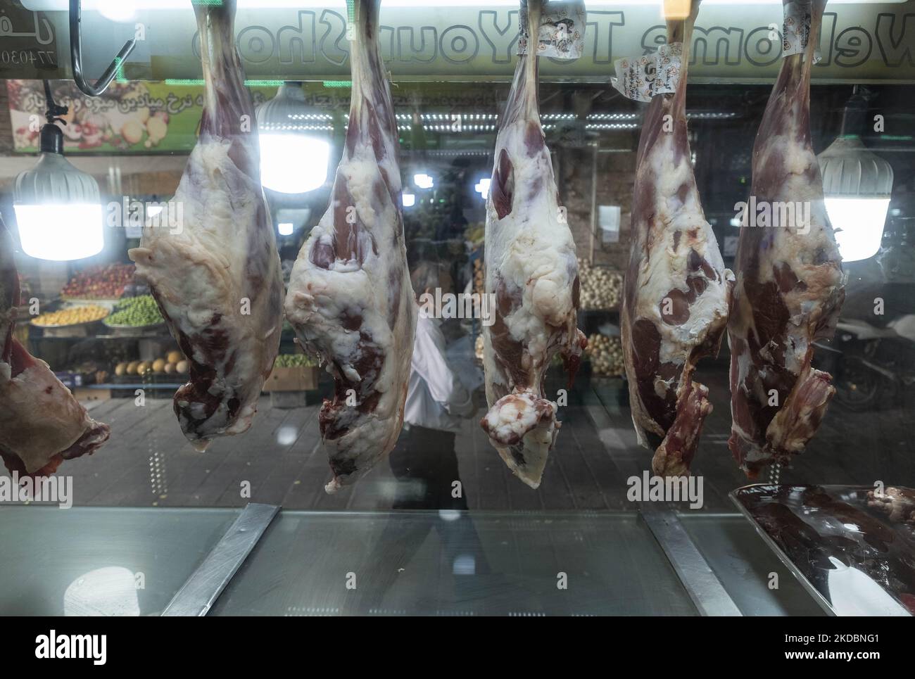 Ein Iraner kommt am 7. Juni 2022 an Fleisch vorbei, das am Fenster einer Metzgerei am Shapour Bazaar (Markt) im Süden Teherans ausgestellt ist. (Foto von Morteza Nikoubazl/NurPhoto) Stockfoto