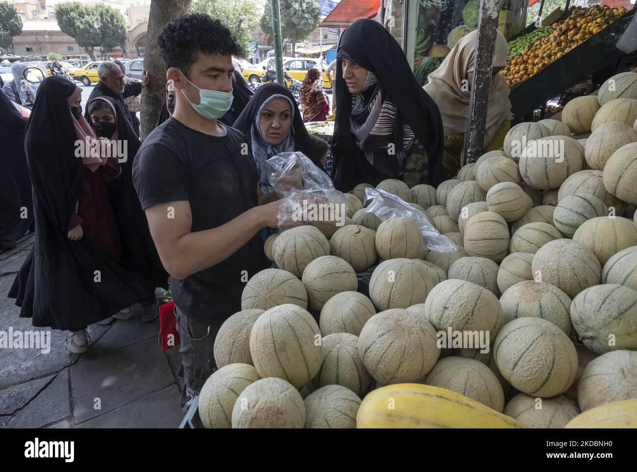 Verschleierte iranische Frauen kaufen am 7. Juni 2022 Kantalupe in einem Obst- und Gemüseladen auf dem Shapour Bazaar (Markt) im Süden Teherans ein. (Foto von Morteza Nikoubazl/NurPhoto) Stockfoto