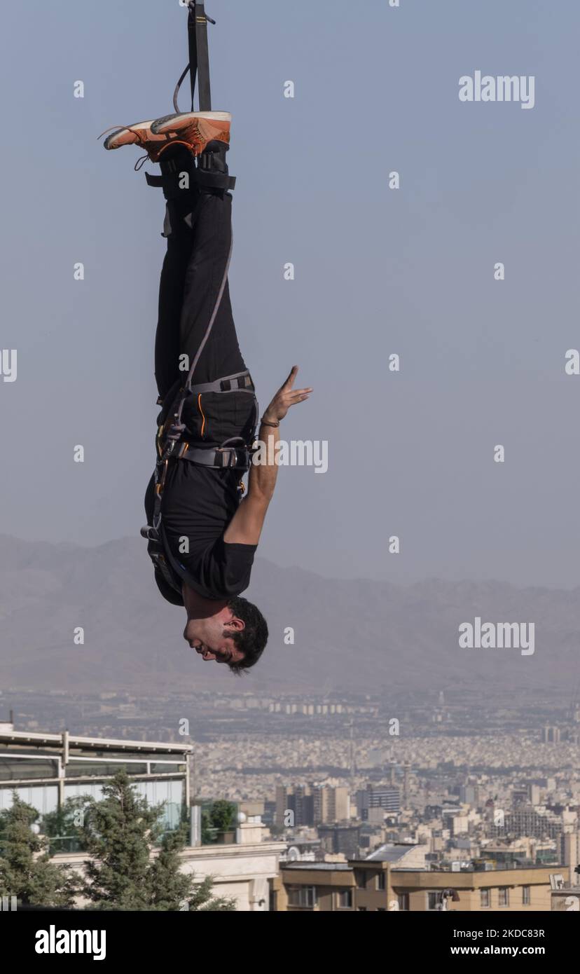 Ein iranischer Bungee-Mann führt am 15. Juni 2022 beim ersten akrobatischen Bungee-Jumping-Wettbewerb des Iran im Adrenaline Park im Nordwesten Teherans ein Bungee-Jumping von einem 40-Meter-Rig aus durch. Der erste akrobatische Bungee-Springen im Iran fand im Adrenaline Park im Nordwesten Teherans statt. (Foto von Morteza Nikoubazl/NurPhoto) Stockfoto