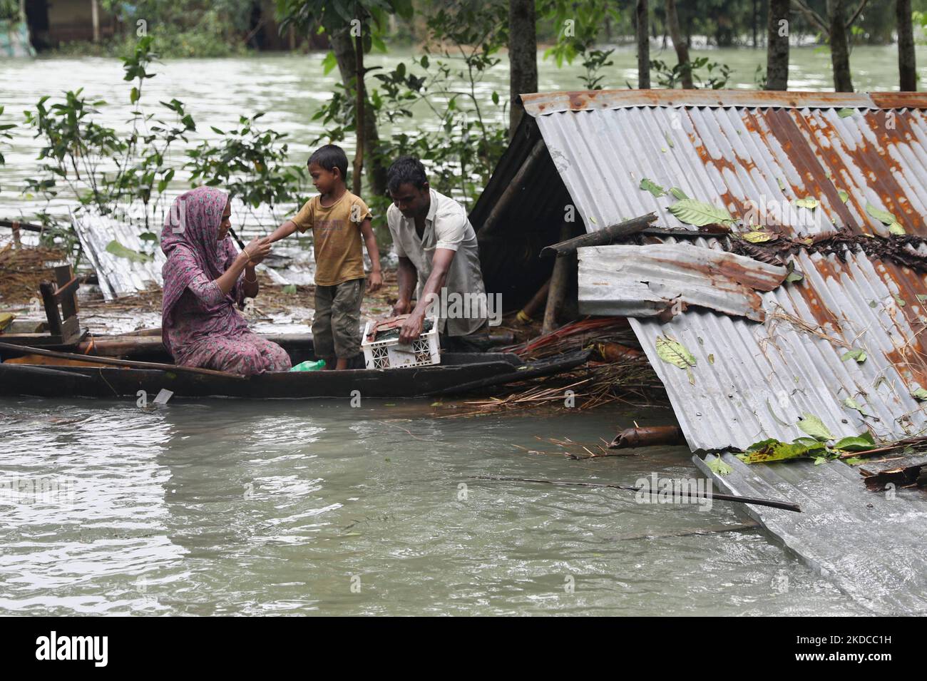 Eine Familie sammelt ihre Waren ein, bevor sie ihr untergetaucht Haus nach einem Sturzflut im Unterdistric Goainghat in Sylhet, Bangladesch, am 19. Juni 2022 verlässt. Monsunstürme in Bangladesch und Indien haben mindestens 59 Menschen getötet und verheerende Überschwemmungen ausgelöst, die Millionen von anderen gestrandet haben, sagten Beamte. (Foto von Syed Mahamudur Rahman/NurPhoto) Stockfoto