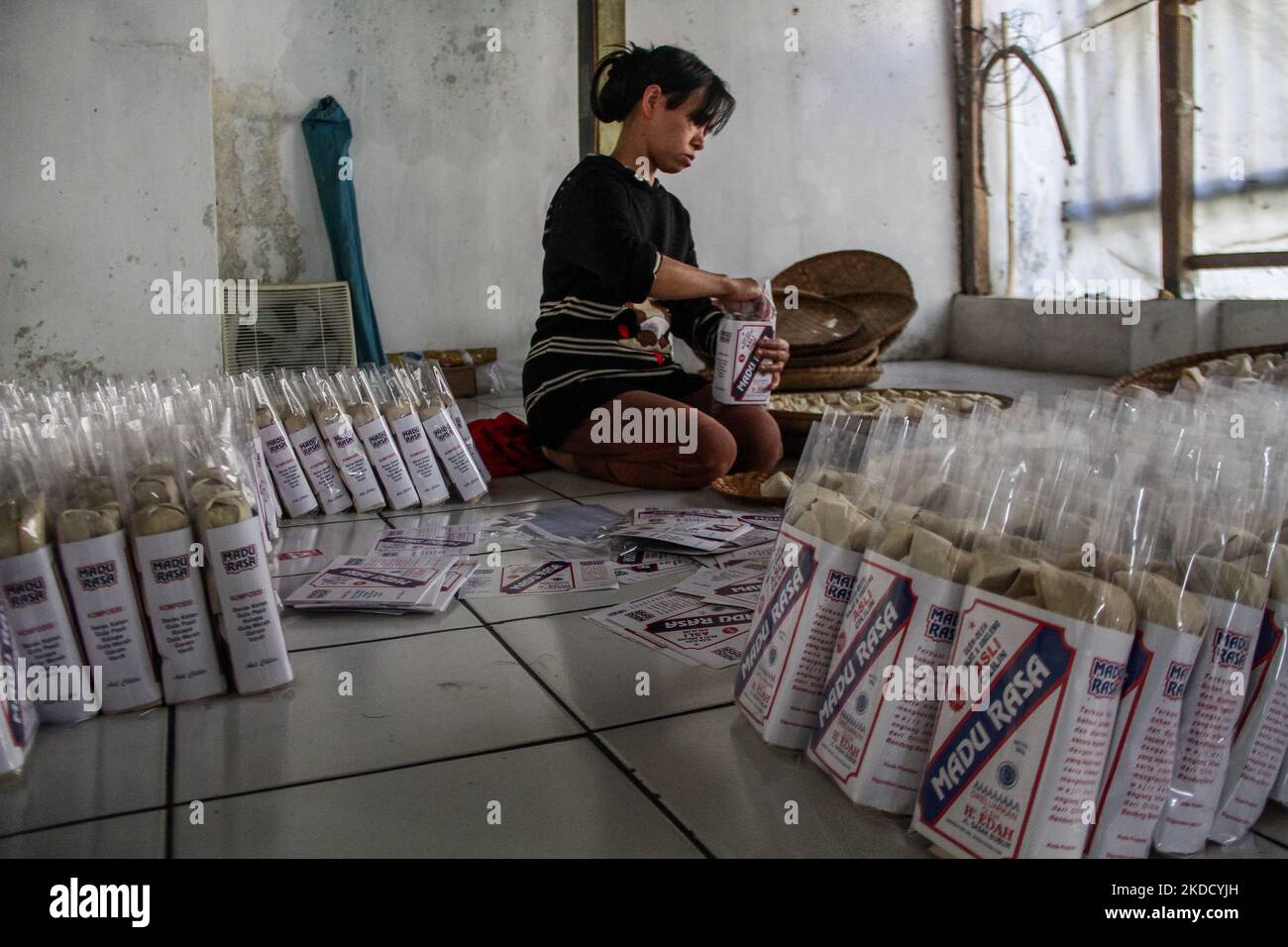 Am 29. Juni 2022 wird in Cihampelas, Cililin, West Bandung Regency, eine Frau beim Verpacken traditioneller Wajit-Lebensmittel beobachtet. West-Java, Indonesien. Die Händler sagten, dass Ende Juni 2022 der Umsatz mit traditionellen Lebensmitteln Wajit Cililin um bis zu 60 Prozent gestiegen ist oder neun Tonnen pro Monat verkaufen könnte, verglichen mit dem Vorjahr, das aufgrund von COVID-19 nur drei Tonnen pro Monat verkaufte. Wajit ist ein traditionelles Essen, typisch für Cililin, West Bandung Regency, das aus klejedem Reis, Palmzucker und Kokosnuss hergestellt wird. (Foto von Algi Febri Sugita/NurPhoto) Stockfoto