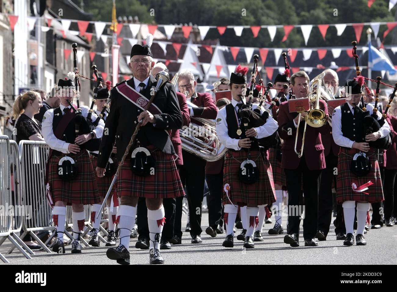 Peebles, Großbritannien - 25. Juni: Peebles Beltane - Red Letter Day Peebles Beltane Festival. Das Pipe Band führt die Kinder zur Kirchentheppe, zur Krönungszeremonie. Der Samstag ist der Höhepunkt der Woche für alle Beteiligten am Beltane. Darauf hat die Beltane Queen gewartet, seit ihr fünf Wochen zuvor mitgeteilt wurde, dass sie die gekrönte sein sollte. Dies ist der große Tag für die krönende Dame, aber vor allem ist dies der große Tag für fast fünfhundert Schulkinder, die mit Stolz Kostüme zu tragen bekommen haben, wenn sie die High Street entlang marschieren; stell dich auf die Stockfoto