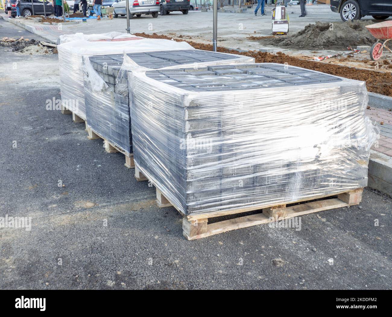 Reparatur des Straßenbelags. Pflastersteine auslegen. Pflastersteine in Paletten aus Polyethylen. Reparaturarbeiten. Stockfoto