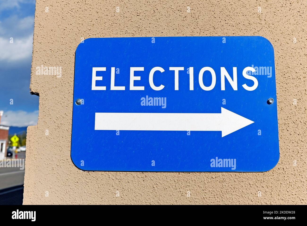 Ein blaues Wandschild mit einem Pfeil, der nach rechts zeigt und die WAHLEN in Weiß geschrieben sind. Stockfoto