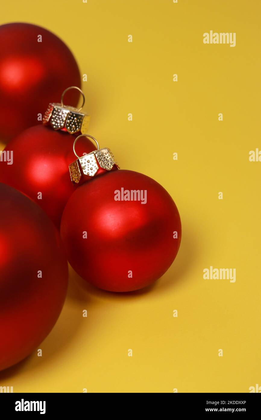 Rote Weihnachtskugeln auf gelbem Hintergrund. Flach liegend, Draufsicht, Kopierbereich Stockfoto