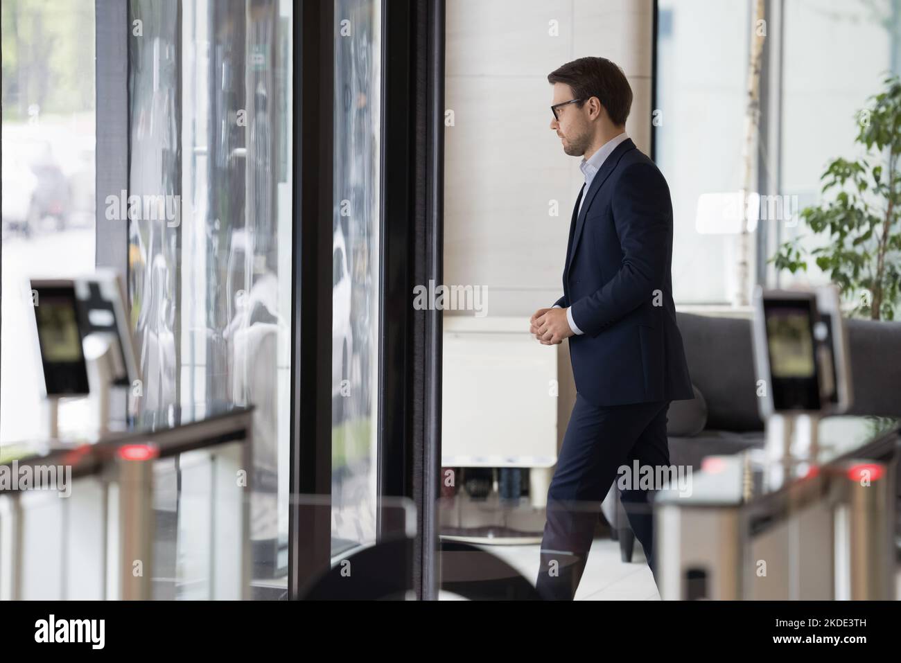 Millennial Geschäftsmann in formellen Anzug verlassen Bürogebäude Bereich Stockfoto