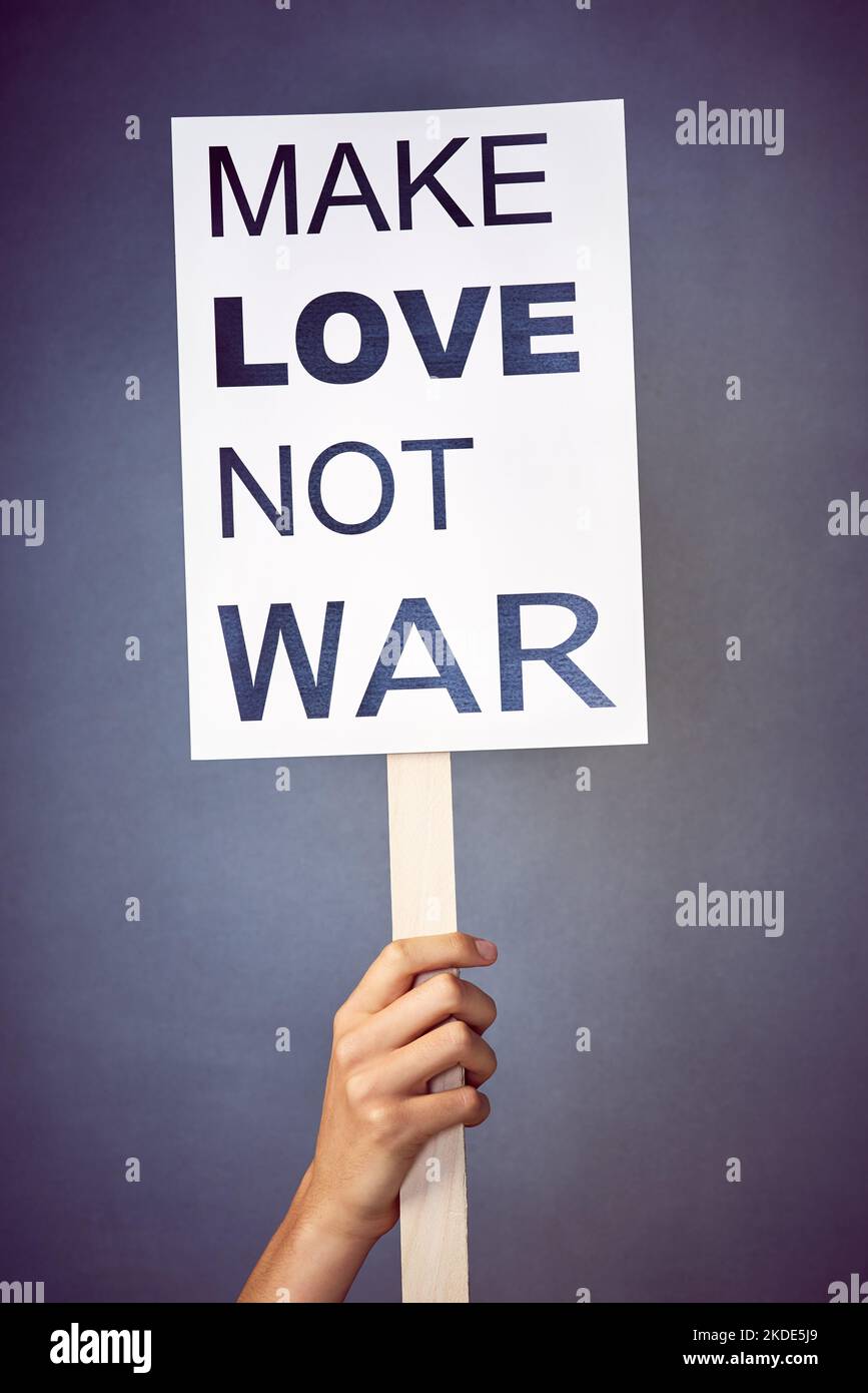 Eine nicht identifizierbare junge Frau hält im Studio ein Plakat mit einer Botschaft auf. Stockfoto