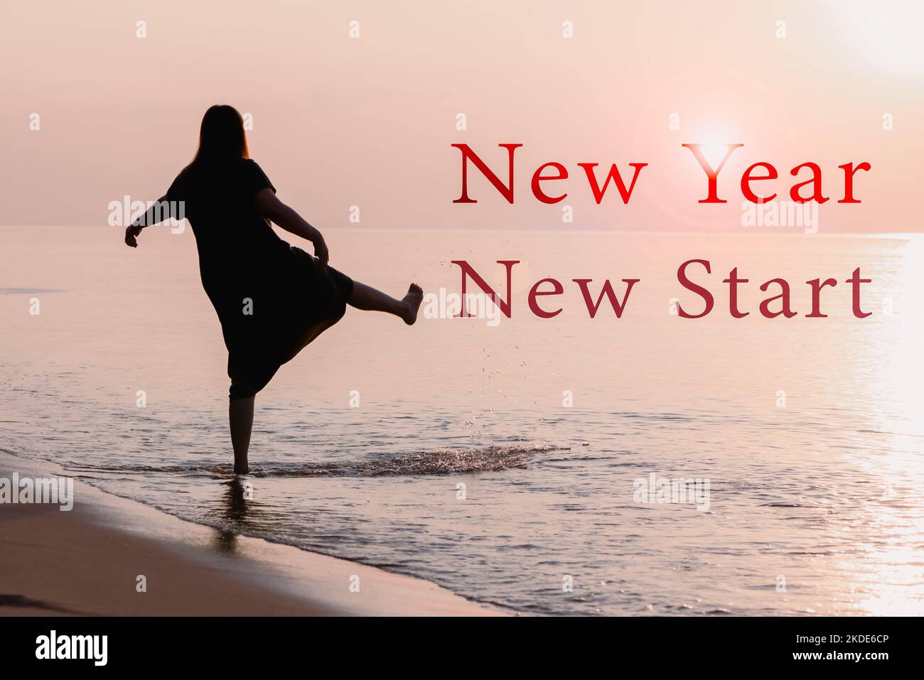 2023 Neujahrsstart, gesunde Frau tritt bei Sonnenaufgang ins Spritzwasser. Entspannung und glückliches Leben. Stockfoto