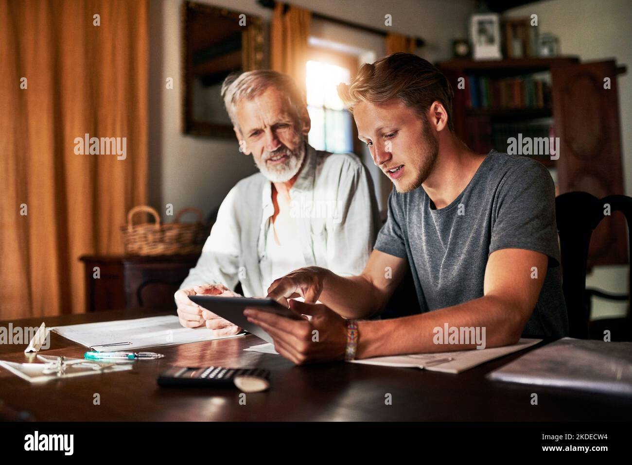 Hier eine bessere Erklärung. Zwei Männer arbeiten zu Hause an einem Projekt zusammen. Stockfoto