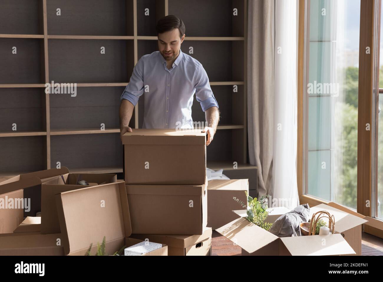 Mann Hausbesitzer Auspacken Habseligkeiten aus Boxen bei Umzug Stockfoto