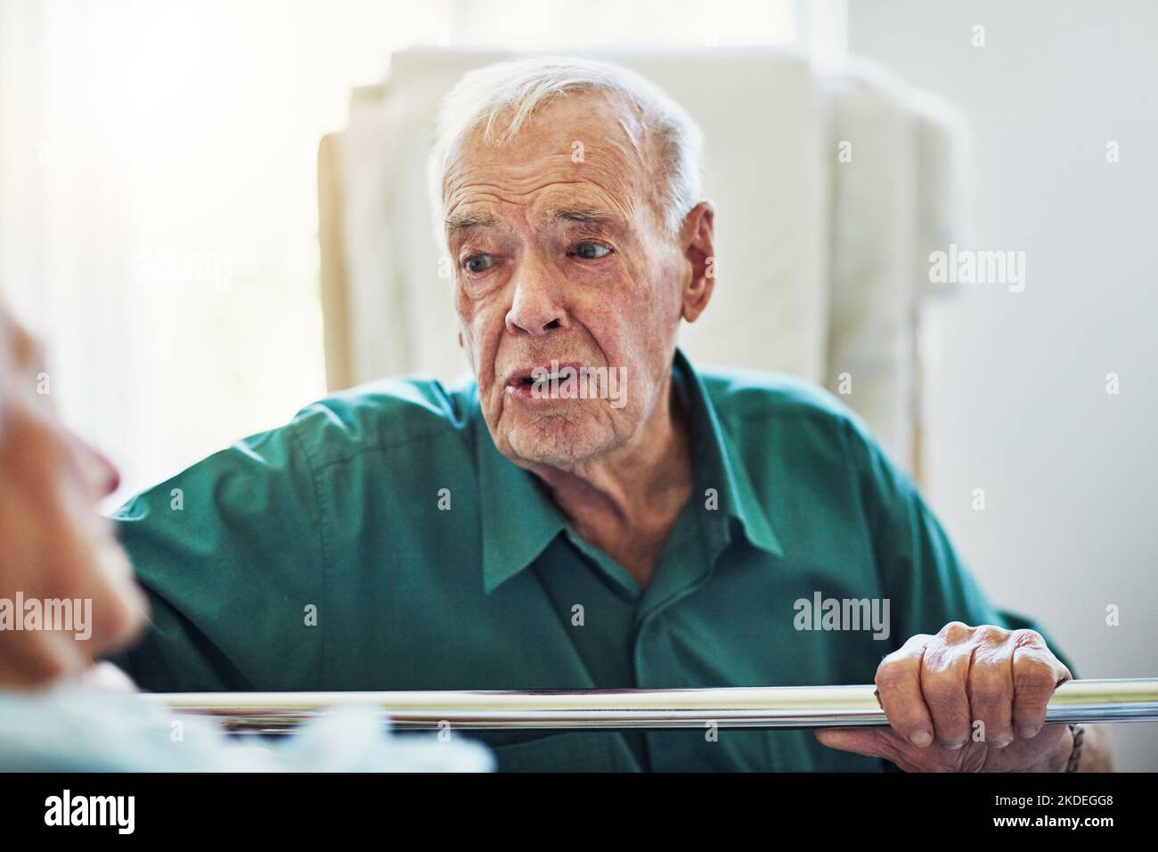 Ein älterer Mann besucht seine kranke Frau im Krankenhaus. Stockfoto