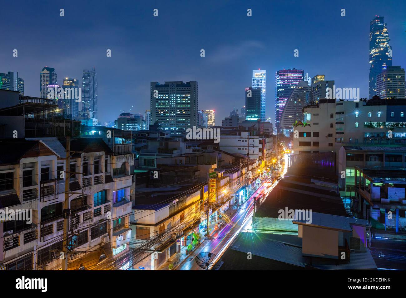 Nachtansicht der Straße im Sathon Bezirk, mit King Power Mahanakhon Turm und Saint Louis Krankenhaus im Hintergrund, Bangkok Stockfoto
