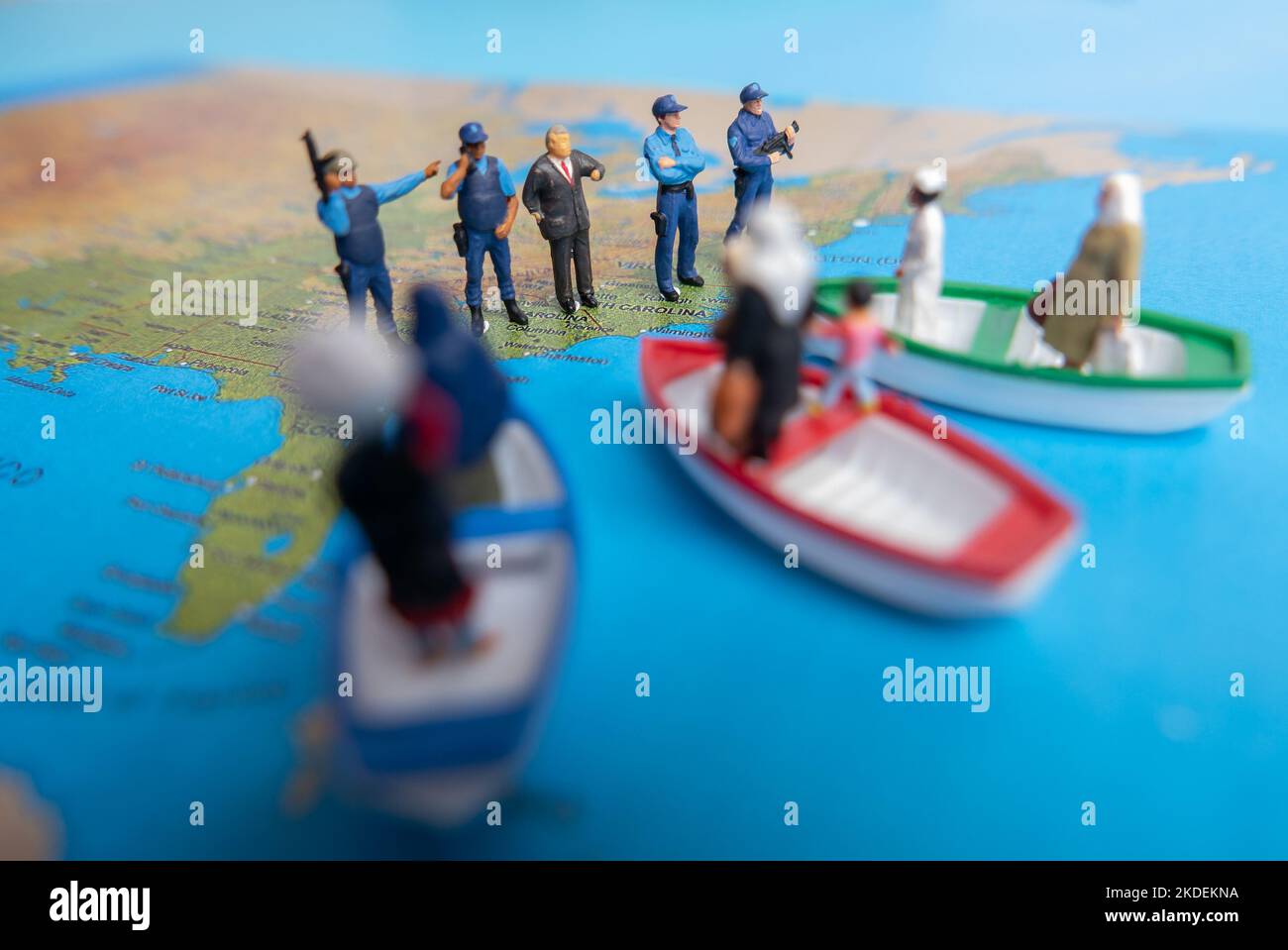 Miniatur-Menschenkonzept der Menschen aus dem Nahen Osten kommen mit dem Boot an die Grenze der USA. Stockfoto