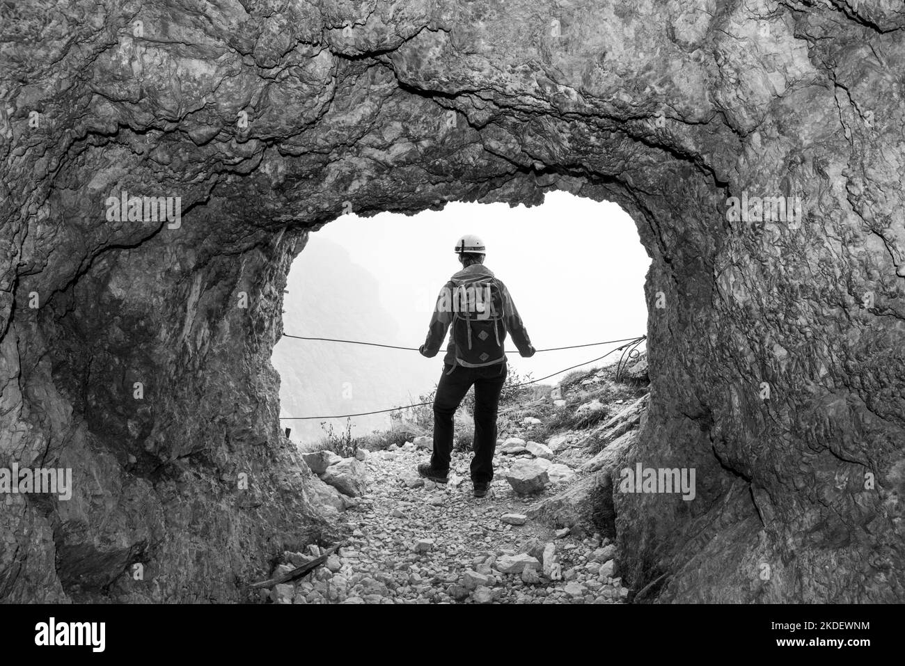 Ein Wanderer, der den Blick aus einem alten Militärtunnel am Lagazuoi, der autonomen Provinz Südtirol, genießt Stockfoto