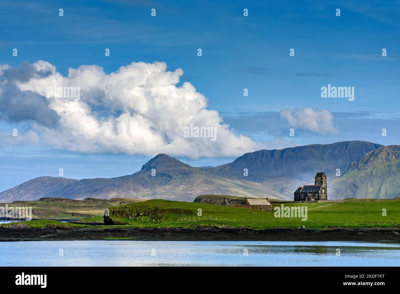 Die ehemalige Kirche von St. Edward auf der Insel Sanday, von der Isle of Canna, Schottland, Großbritannien. Dahinter liegen die Berge der Isle of Rum. Stockfoto