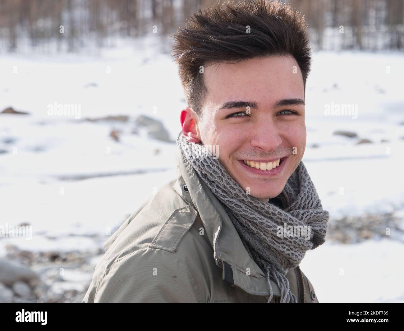 Junger Mann in den Bergen im Winter mit Schnee Stockfoto