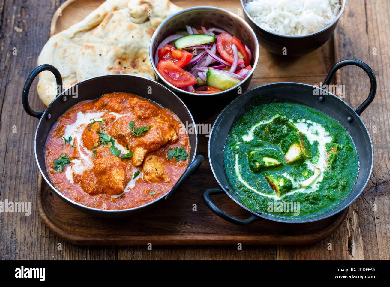 Butterhuhn, saag Paneer, Toamto-Salat und Naan-Brot Stockfoto