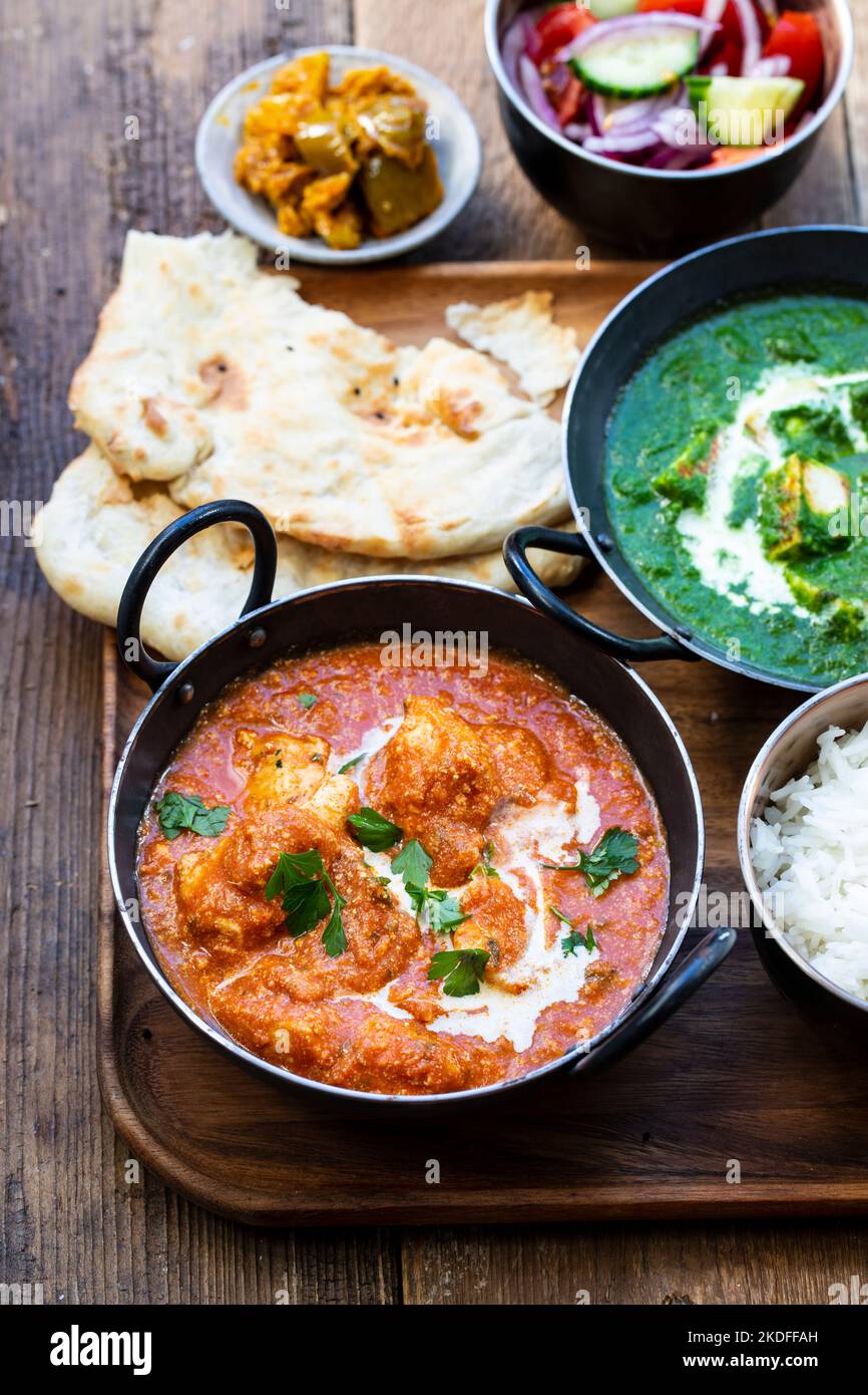 Butterhuhn, saag Paneer, Toamto-Salat und Naan-Brot Stockfoto
