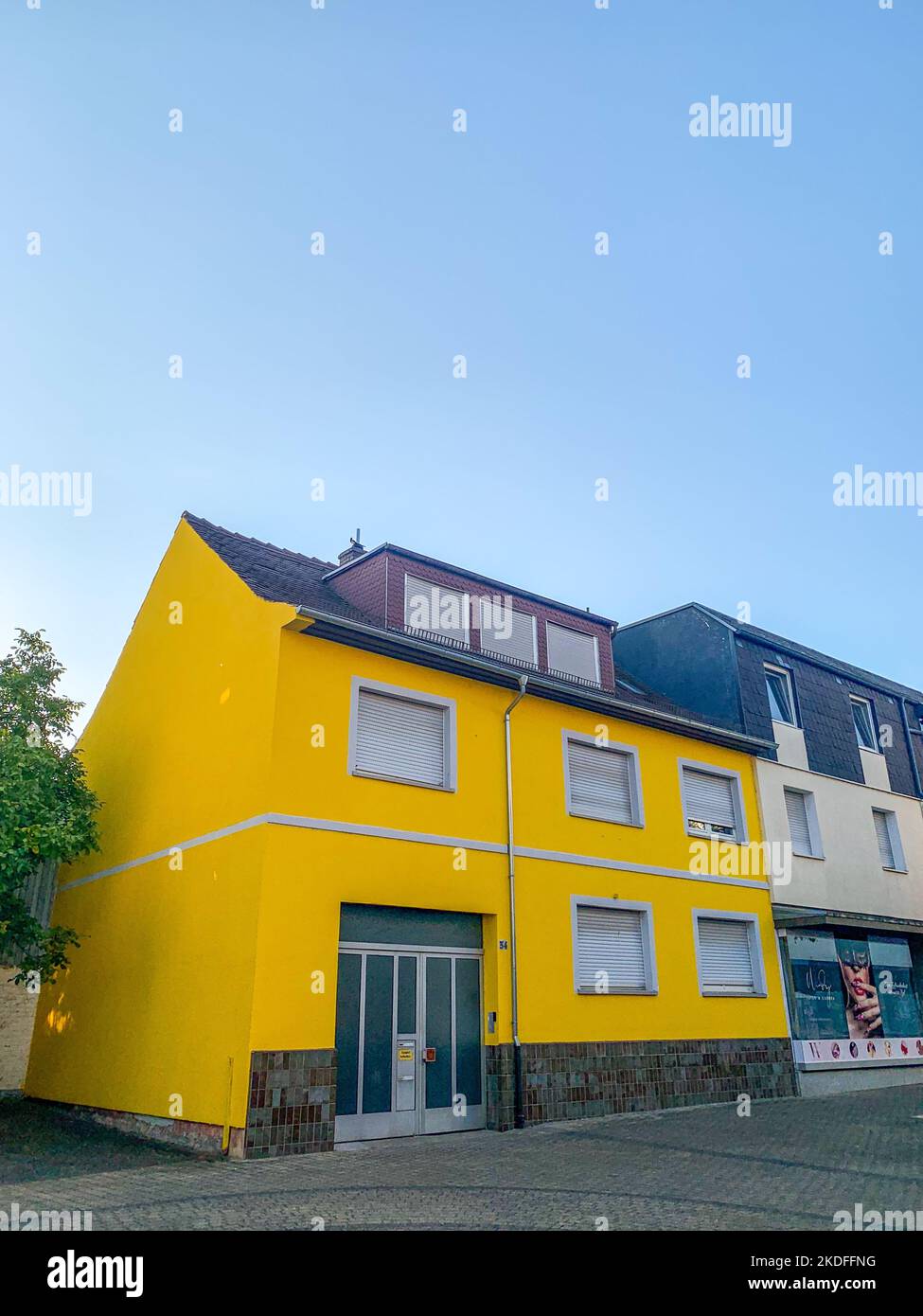 Eine vertikale Aufnahme eines gelben Hauses in Muhlheim am Main in Deutschland Stockfoto