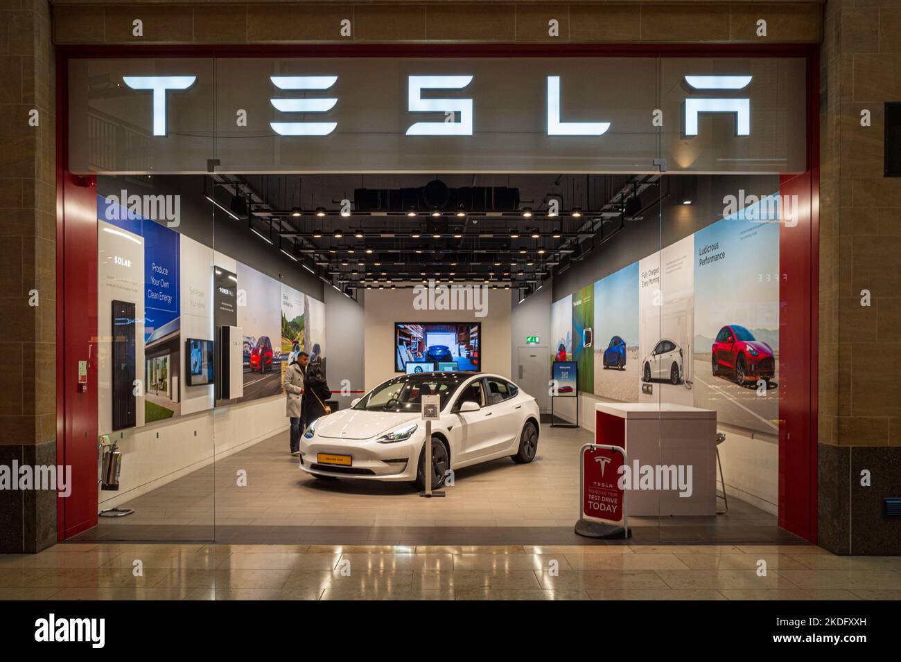 Gebrauchte Tesla Cars Tesla Showroom - Kunden sehen ein gebrautes Tesla Model 3 Elektroauto im Tesla Showroom in der Grand Arcade Shopping Mall Cambridge UK Stockfoto