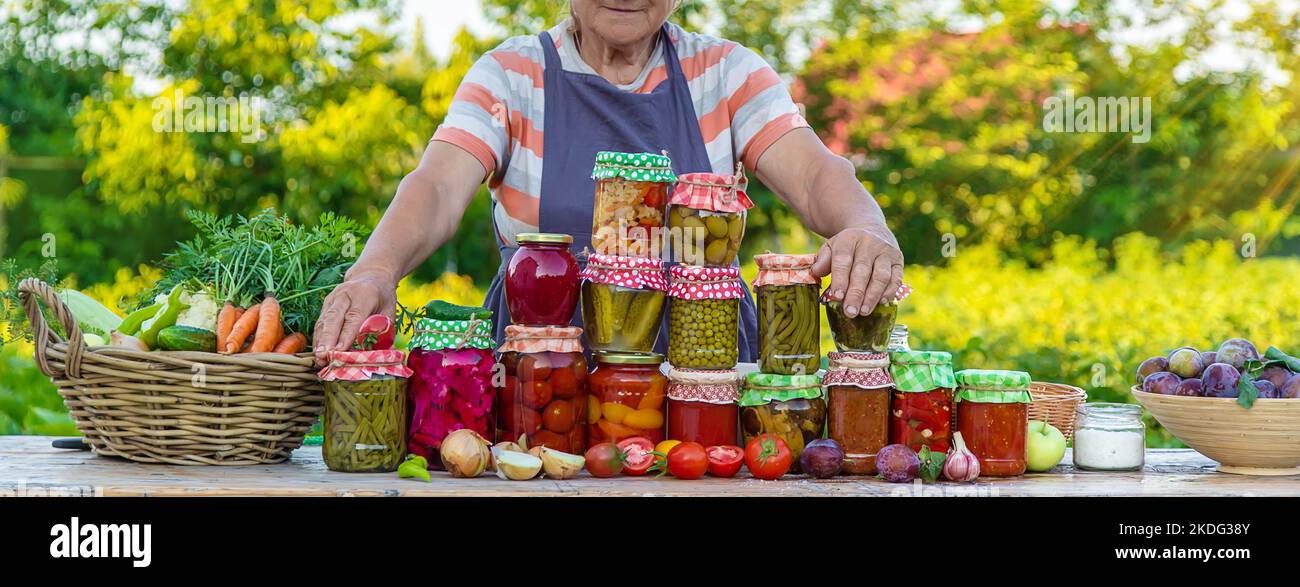 Ältere Frau, die Gemüse in Gläsern konservieren. Selektiver Fokus. Essen. Stockfoto