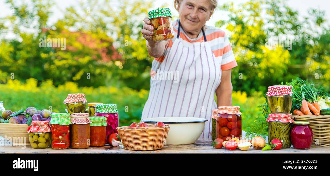 Ältere Frau, die Gemüse in Gläsern konservieren. Selektiver Fokus. Essen. Stockfoto