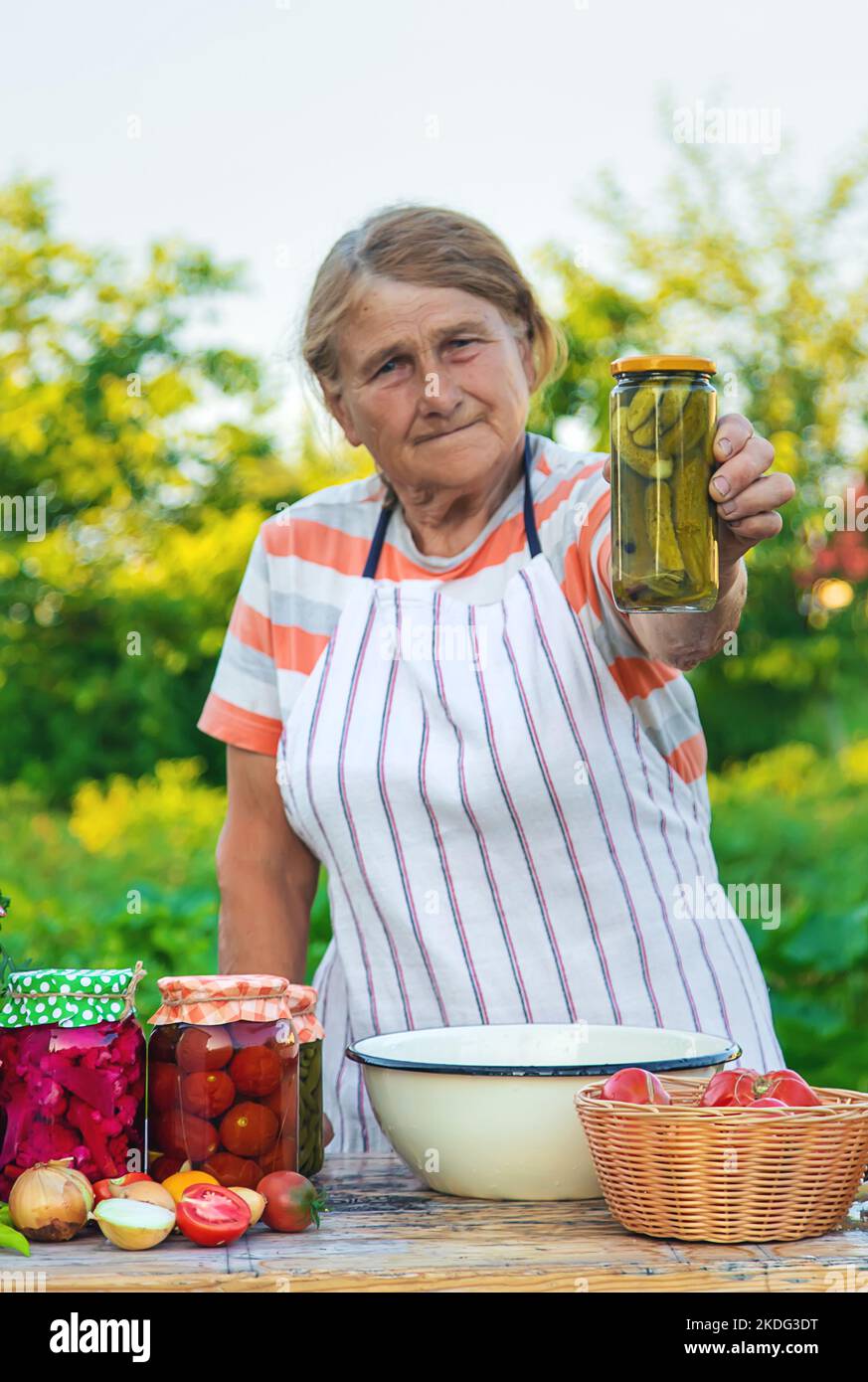 Ältere Frau, die Gemüse in Gläsern konservieren. Selektiver Fokus. Essen. Stockfoto