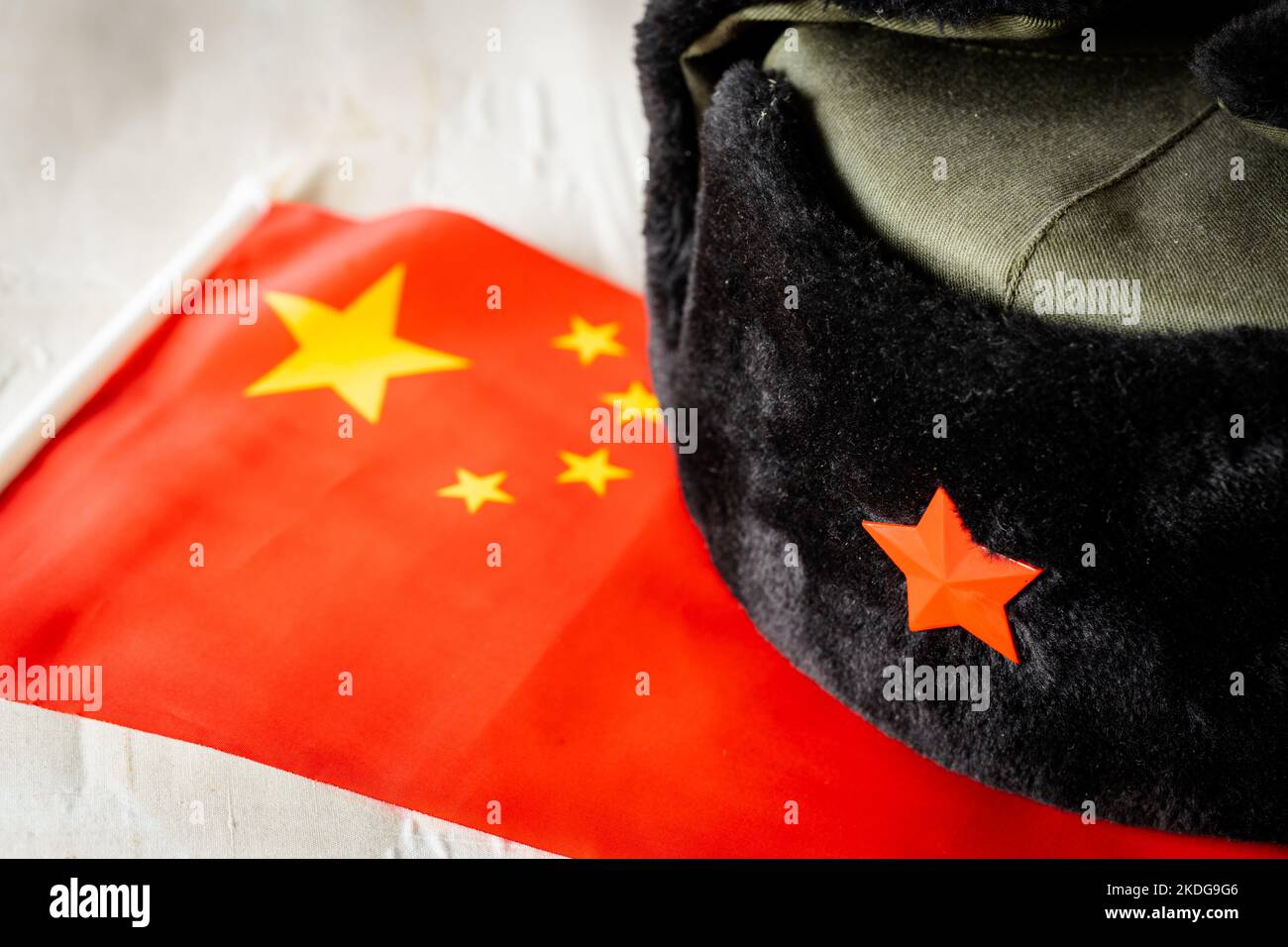 Chinesische Flagge und militärische Deckelung, Konzept, Chinas militärische Expansion und aggressive Politik Stockfoto