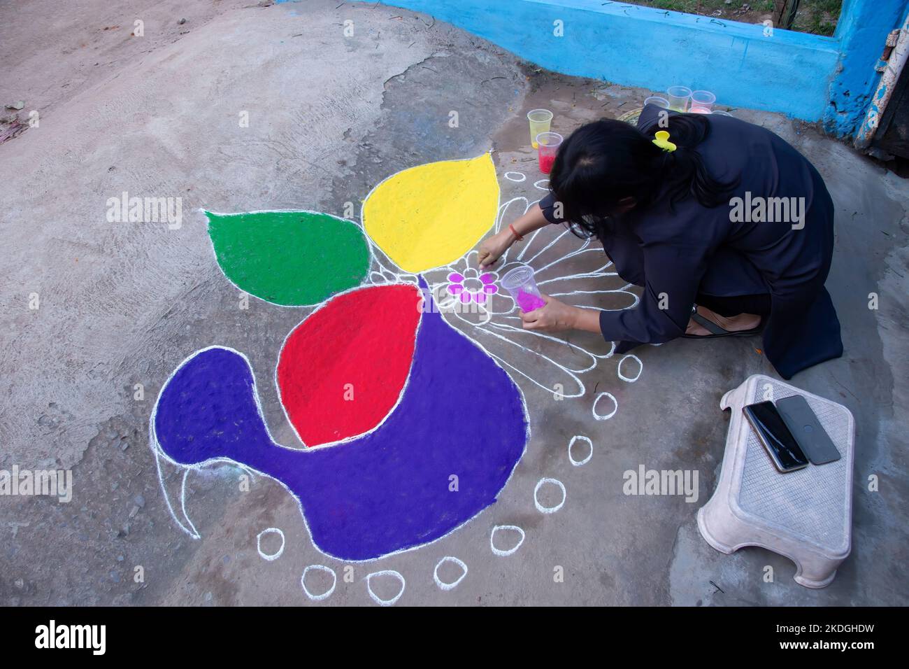 Stammesvolk, das am Vorabend von Diwali Rrangoli zieht Stockfoto