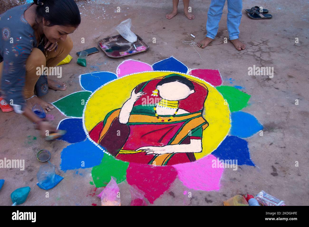 Stammesvolk, das am Vorabend von Diwali Rrangoli zieht Stockfoto