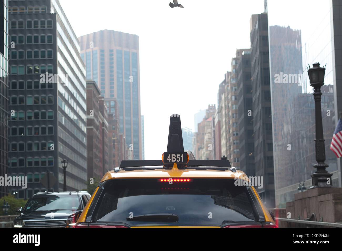 Manhattan, New York City Canyon von Wolkenkratzern Straße hinter einem gelben Taxi Stockfoto